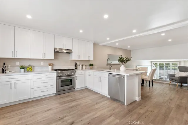 a kitchen with a white stove top oven cabinets and wooden floor