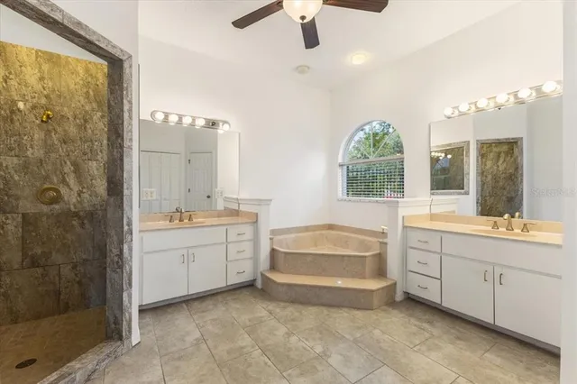 a spacious bathroom with a double vanity sink a large mirror and a bathtub