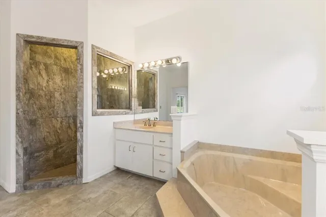 a bathroom with a tub sink and mirror