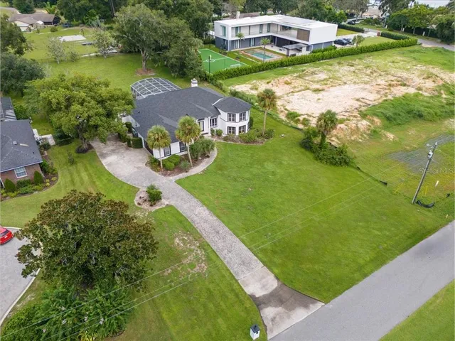 an aerial view of a house with a garden and lake view