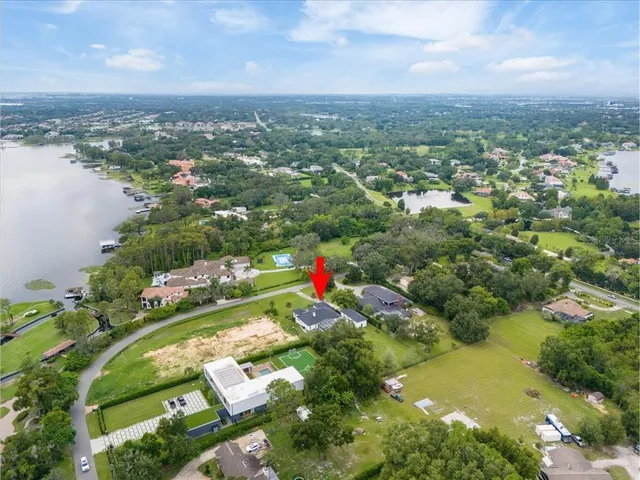 an aerial view of residential houses with outdoor space and lake view