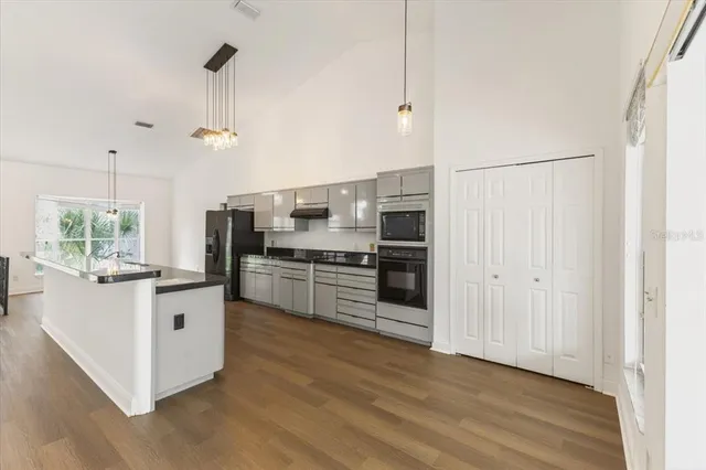 a kitchen with stainless steel appliances a refrigerator and a stove top oven
