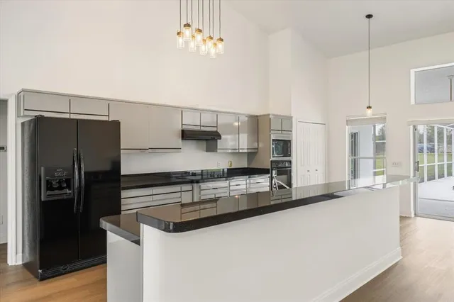 a kitchen with stainless steel appliances a sink a stove a refrigerator and cabinets