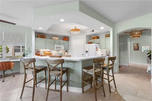 a kitchen with stainless steel appliances kitchen island granite countertop a table and chairs