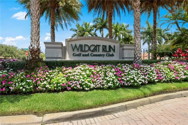 a street sign with potted plants and palm trees