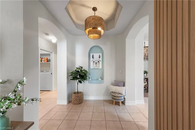 a view of a hallway with entryway dining room and chandelier
