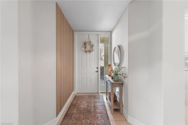 a view of a hallway with wooden floor and a dining room