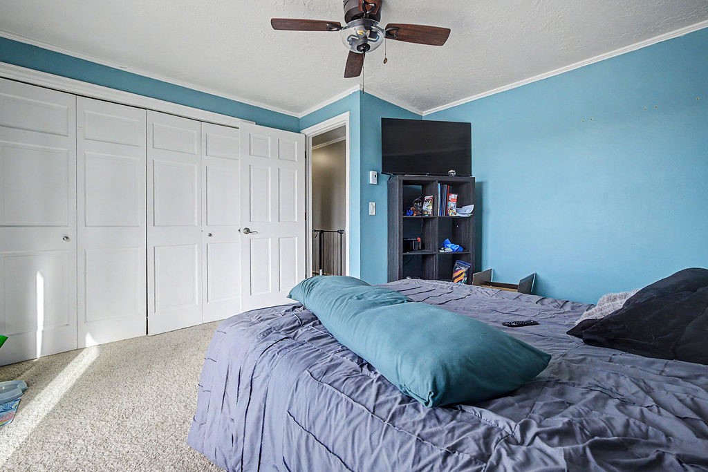2014 East 9th Street Craig, CO 81625 - Photo 18 of 29 a bedroom with a large bed and a chandelier