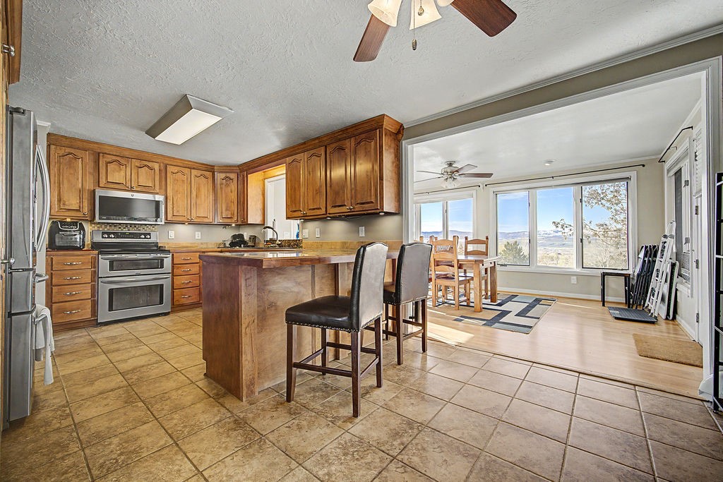 2014 East 9th Street Craig, CO 81625 - Photo 6 of 29 a kitchen with granite countertop a table chairs microwave and refrigerator