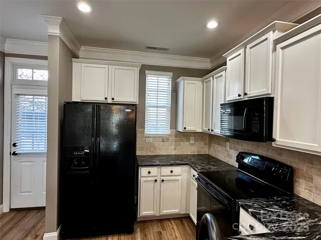 a kitchen with stainless steel appliances granite countertop a refrigerator stove and microwave