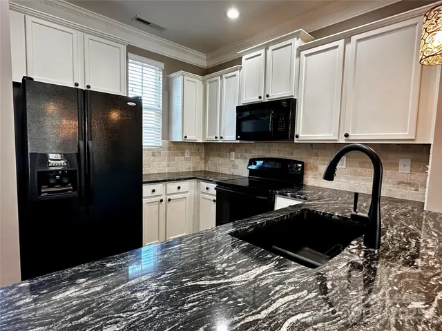 a kitchen with a refrigerator a stove a sink and cabinets