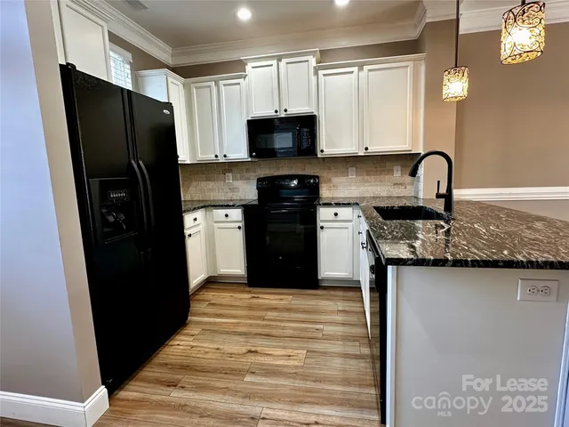 a kitchen with granite countertop stainless steel appliances and a refrigerator