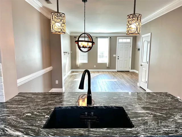 a view of a hallway with window and chandelier