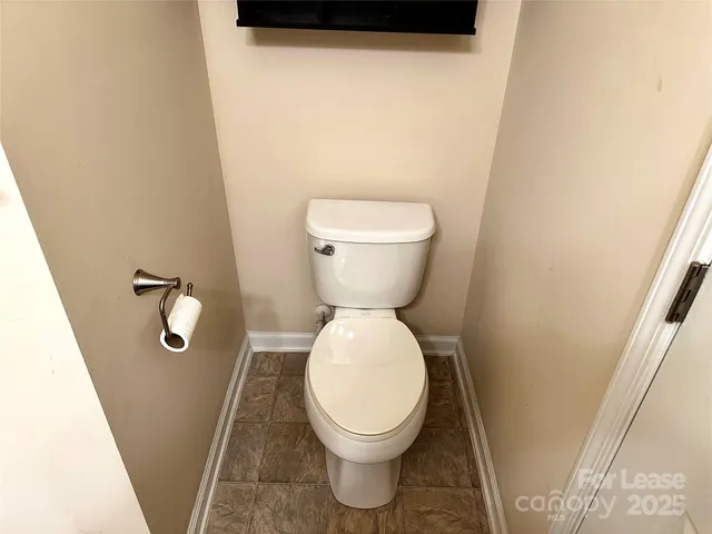 a white toilet sitting in a bathroom next to a sink