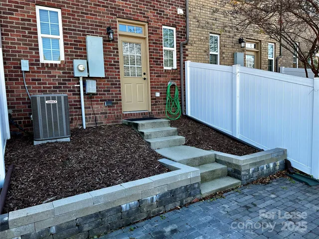 a view of a backyard with chairs and a fence