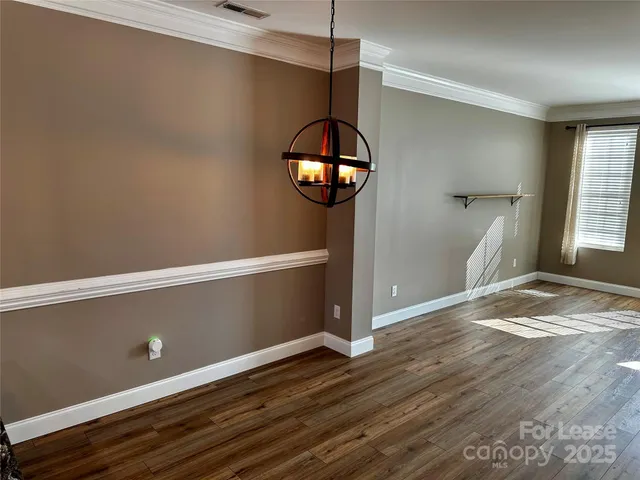 a view of a room with wooden floor and entryway