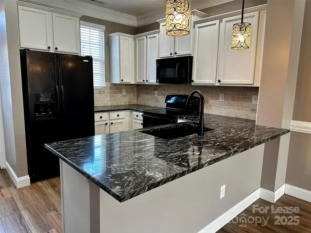a kitchen with stainless steel appliances granite countertop a coffee maker on granite counter tops and white cabinets