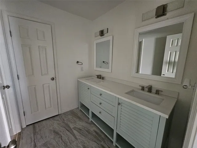 a bathroom with a double vanity sink and mirror