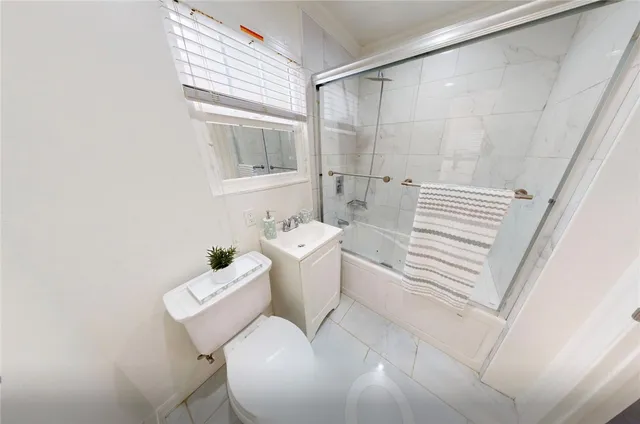 a view of an empty room with wooden floor and windows