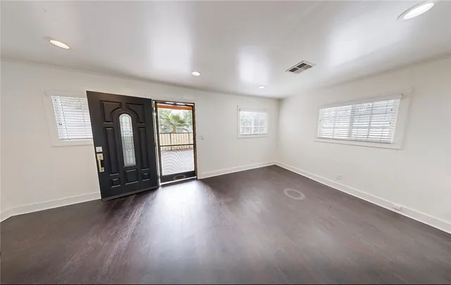 a view of empty room with wooden floor