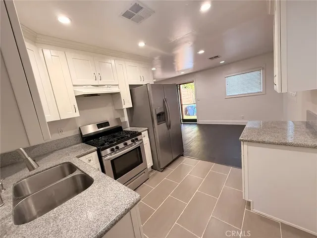 a kitchen with granite countertop a stove and a refrigerator