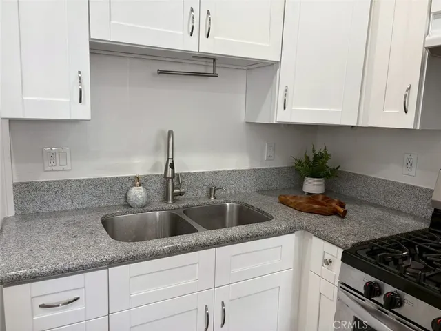 a kitchen with stainless steel appliances granite countertop a sink a stove and cabinets