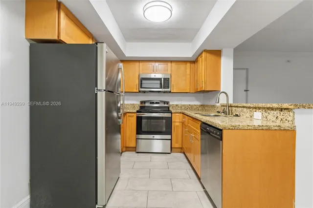 a kitchen with stainless steel appliances granite countertop a stove a sink and a refrigerator