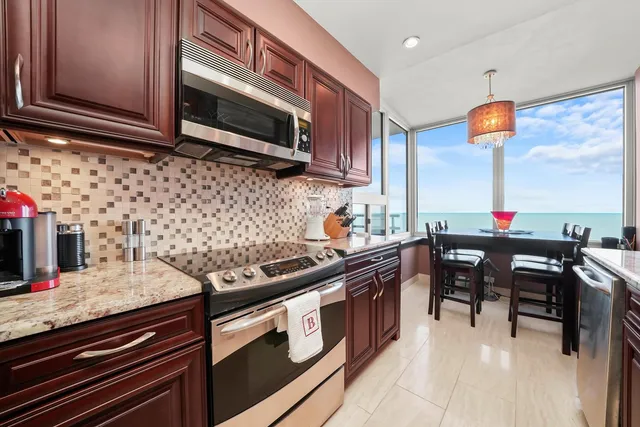 a kitchen with stainless steel appliances granite countertop a stove a sink and a microwave