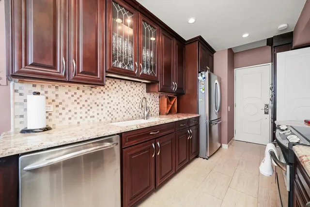 a kitchen with stainless steel appliances granite countertop a refrigerator and a sink
