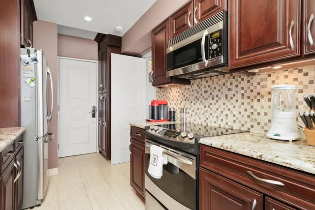 a kitchen with stainless steel appliances granite countertop a stove and a refrigerator
