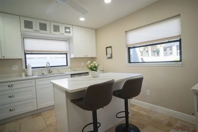 a view of kitchen with cabinets stainless steel appliances and a window