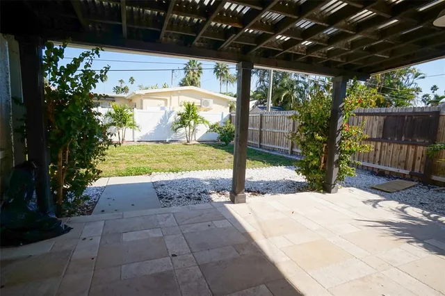 a view of house with backyard and glass windows