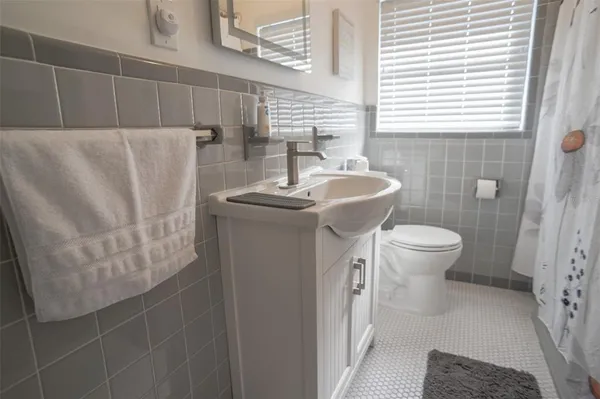 a bathroom with a sink a toilet and a mirror