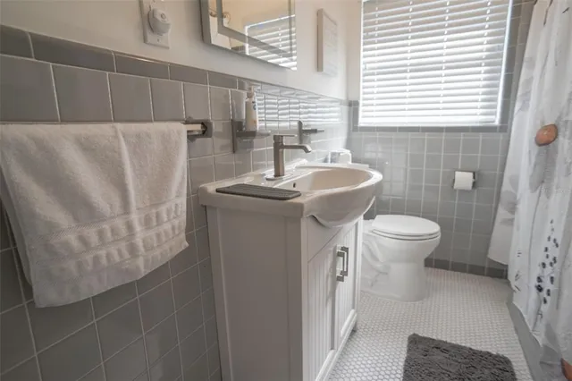 a bathroom with a sink a toilet and a mirror