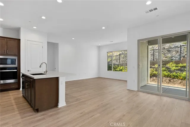a view of kitchen with stainless steel appliances granite countertop cabinets and wooden floor