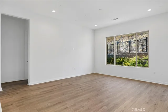 an empty room with wooden floor and window