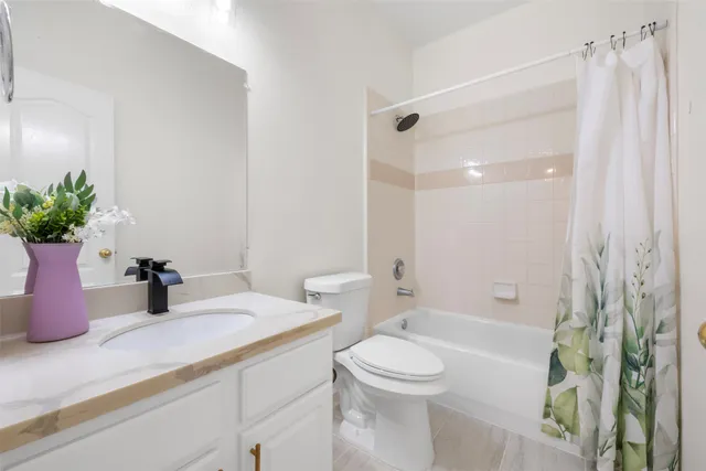 a bathroom with a granite countertop sink a toilet and shower