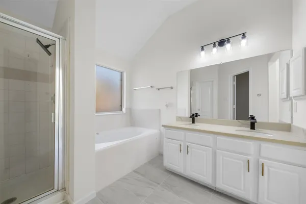 a bathroom with a tub a sink and mirror