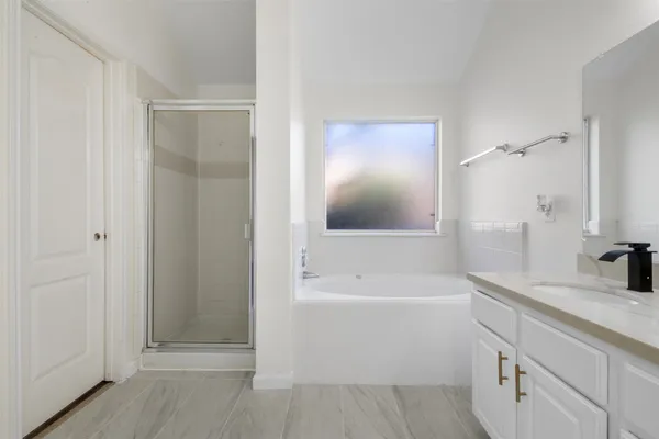a bathroom with a tub sink and mirror