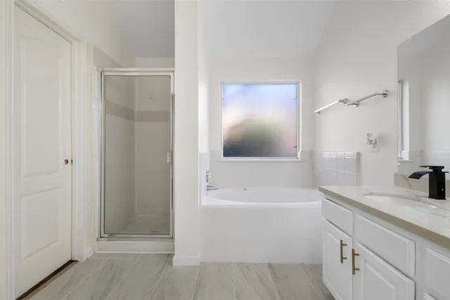 a bathroom with a tub sink and mirror