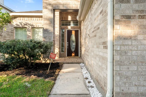 a view of a brick house with a large windows and a pathway