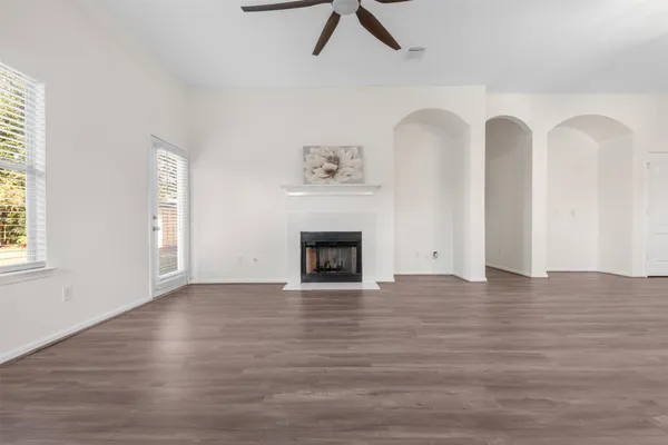 a view of empty room with wooden floor and fireplace