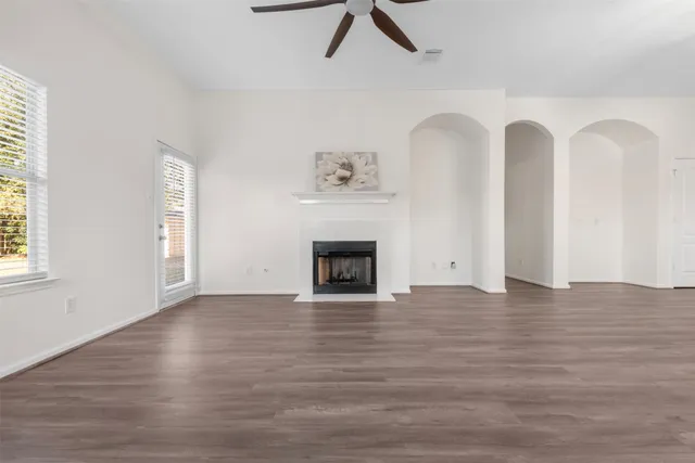 a view of empty room with wooden floor and fireplace