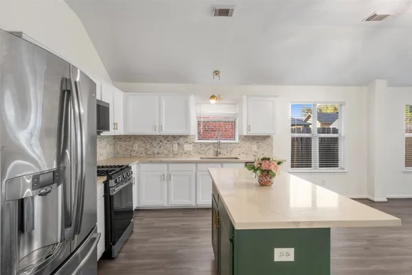 a kitchen with stainless steel appliances granite countertop a sink stove and refrigerator