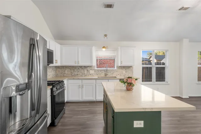 a kitchen with stainless steel appliances granite countertop a sink stove and refrigerator