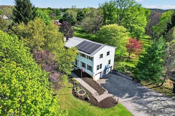a view of a house with a yard and large trees