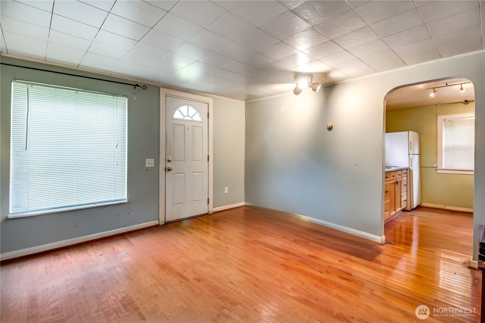 9817 35th Avenue Southwest Seattle, WA 98126 - Photo 2 of 25 an empty room with wooden floor and windows