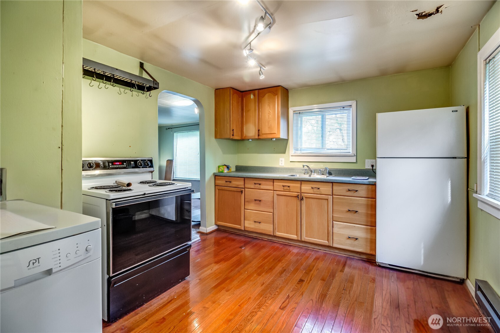 9817 35th Avenue Southwest Seattle, WA 98126 - Photo 4 of 25 a kitchen with a refrigerator stove and wooden floor