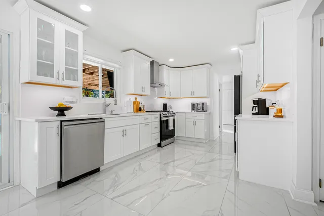 a kitchen with white cabinets and white appliances