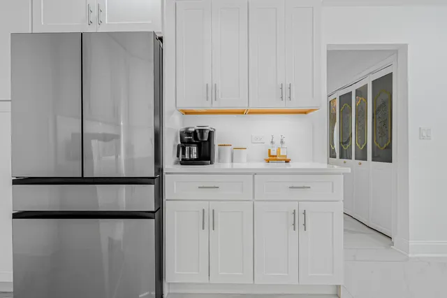a kitchen with stainless steel appliances white cabinets and a refrigerator
